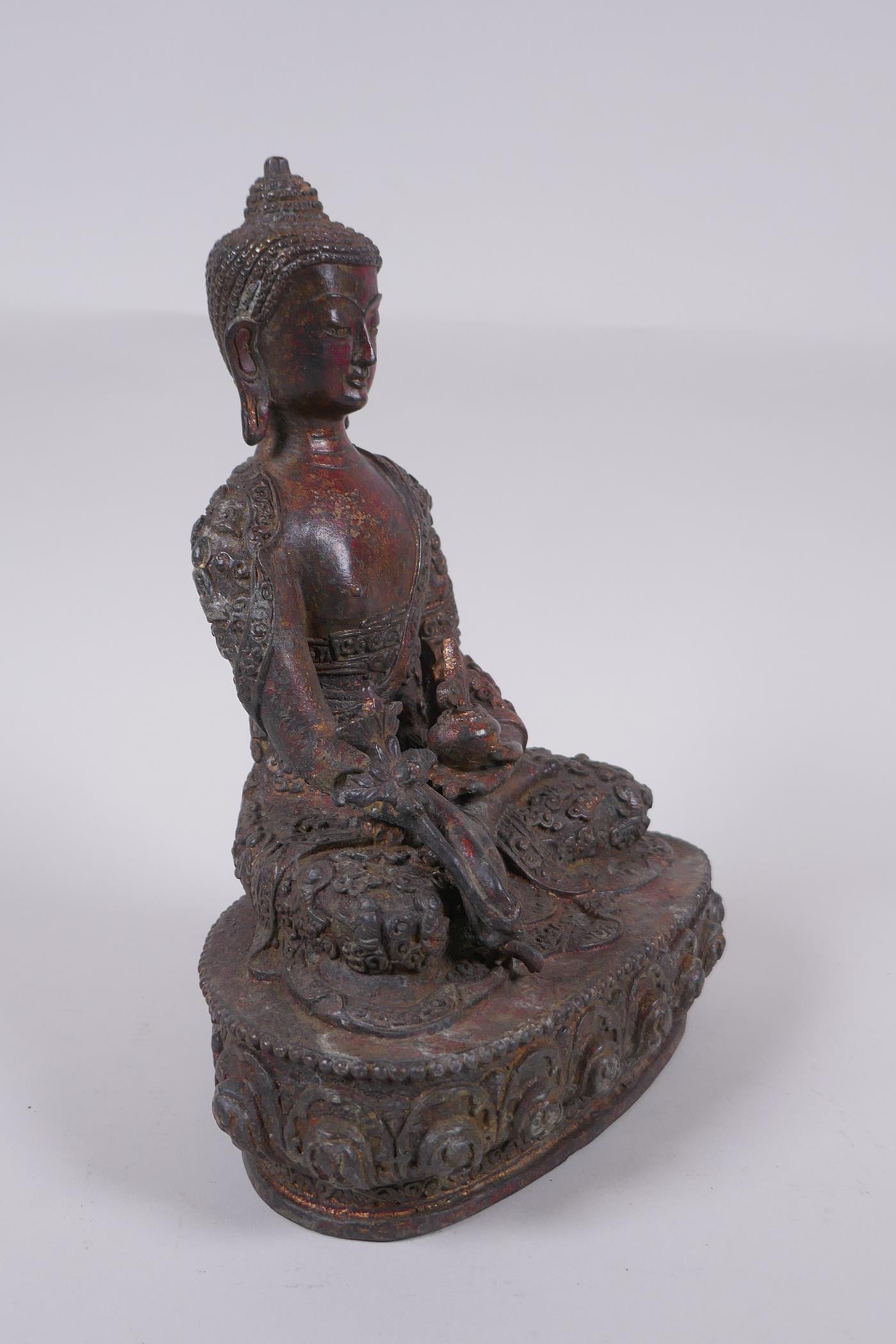 A Tibetan bronzed metal Buddha with the remnants of gilt and copper patina, impressed double vajra - Image 3 of 7