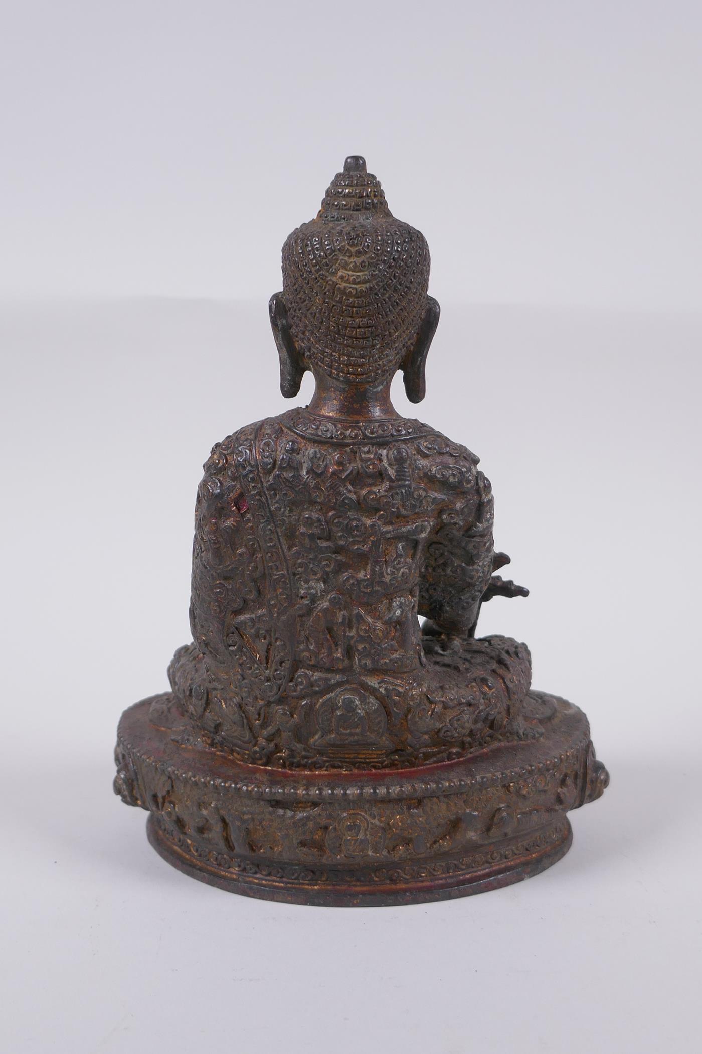 A Tibetan bronzed metal Buddha with the remnants of gilt and copper patina, impressed double vajra - Image 4 of 7