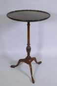 A mahogany wine table on a turned column and tripod supports, the dish top with an engraved circular