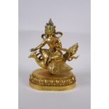 A Sino Tibetan gilt bronze figure of Buddha seated on the back of a phoenix, with inset coral,