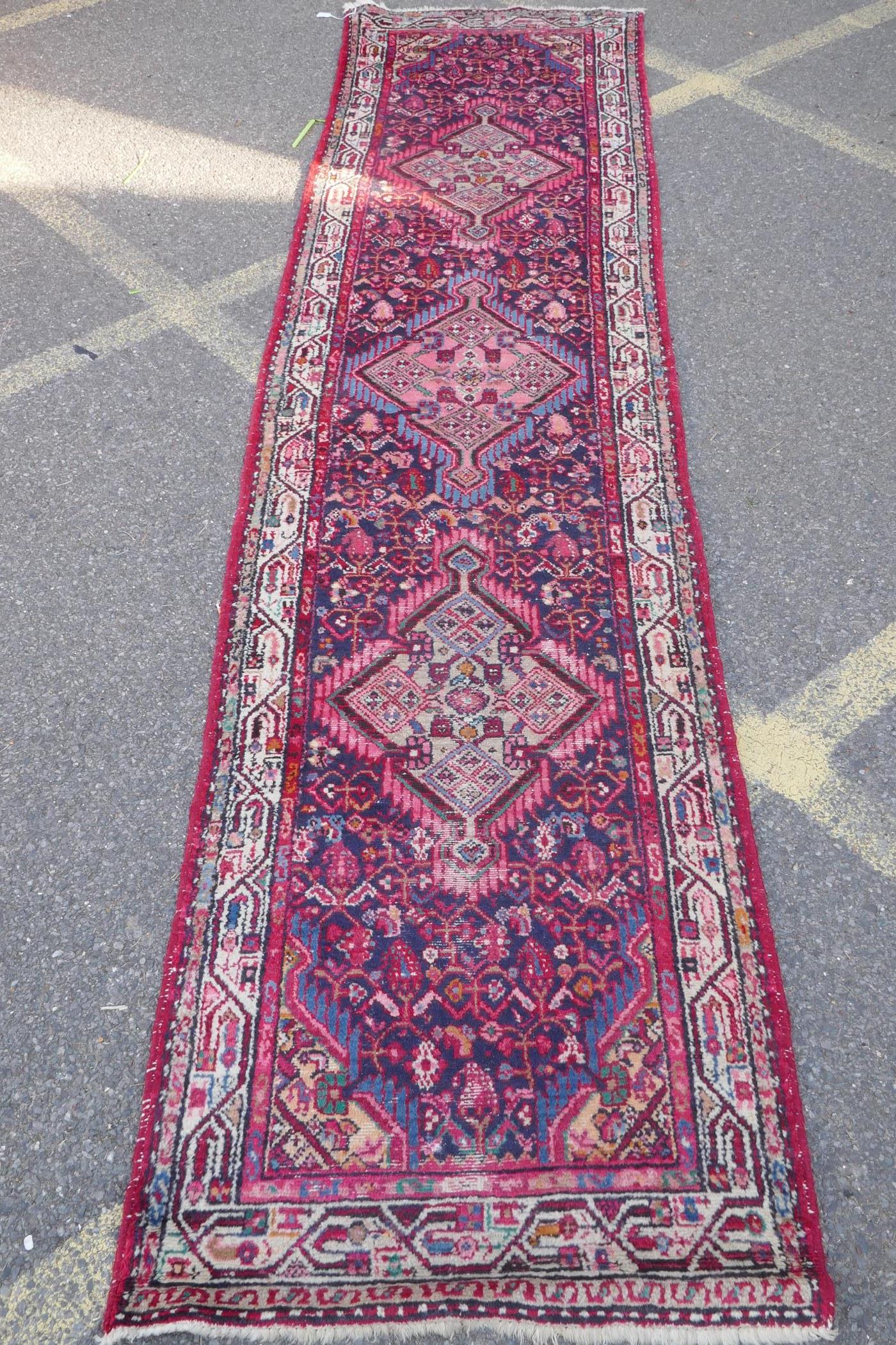 A Persian red ground wool runner with multi colour geometric medallion design, 85 x 340cm - Image 2 of 8