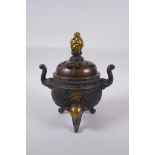 A Chinese bronze two handled censer and cover raised on tripod elephant head feet, with dragon knop,
