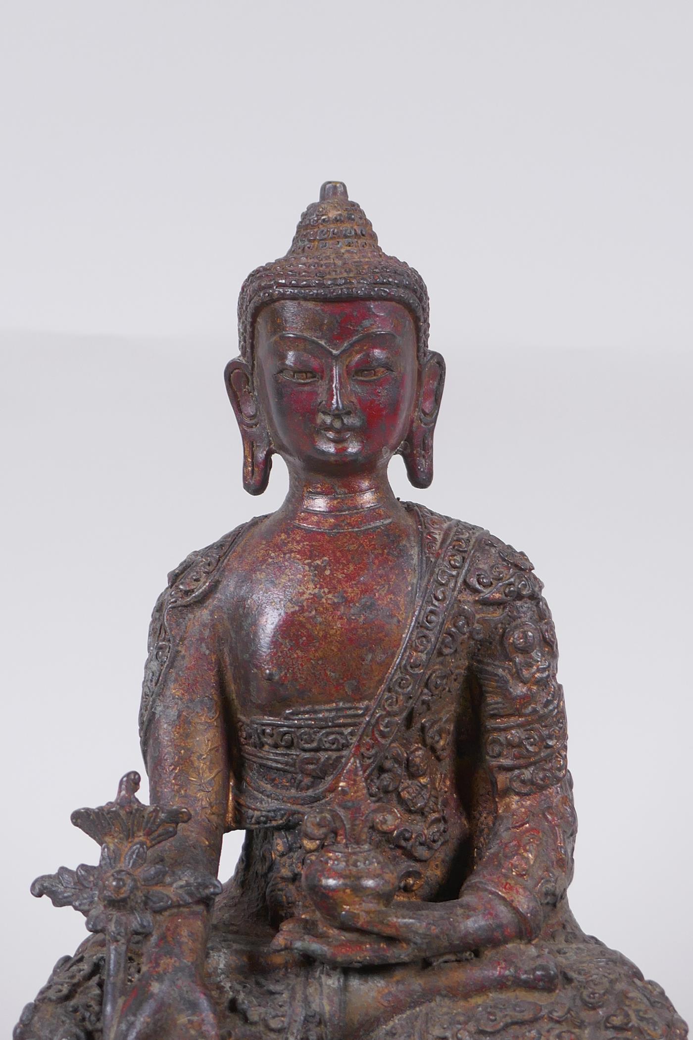 A Tibetan bronzed metal Buddha with the remnants of gilt and copper patina, impressed double vajra - Image 2 of 7