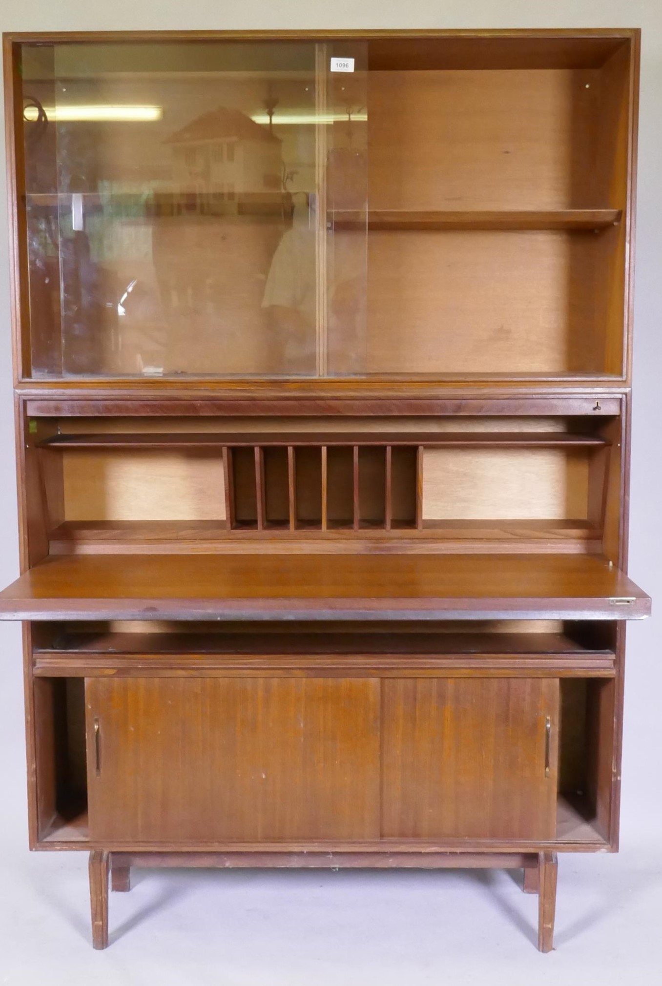 A mid century Beaver & Tapley Ltd multi width teak unit in two sections, the upper with sliding