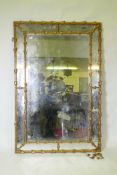 A gilt composition sectional wall mirror with central bevelled plate and antiqued glass border,