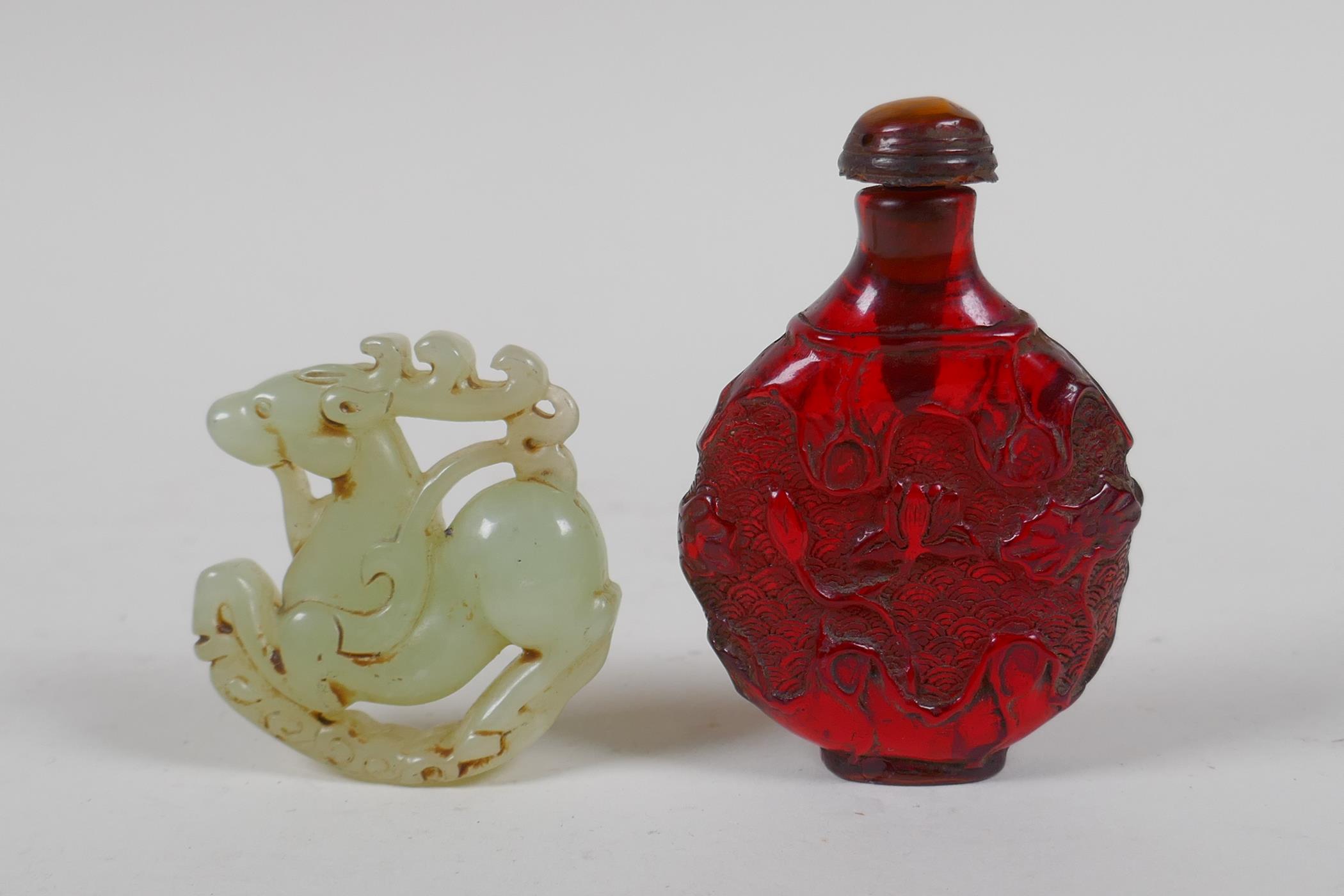 A Chinese carved hardstone roundel in the form of a deer, and a faux amber snuff bottle, 7cm high