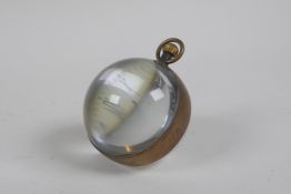 A brass bound glass ball desk clock, 6cm diameter