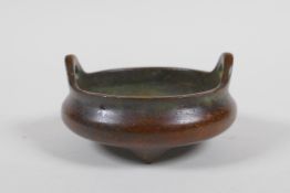 A Chinese bronze censer with phoenix eye handles and tripod supports, impressed mark to base, 9cm