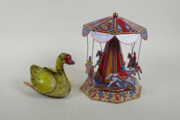 A vintage Chinese Gosling Goose clockwork tin toy, and a later German tin plate Merry-Go-Round,