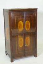 A C19th Continental mahogany four door cabinet with shell inlaid panels raised on block supports, 54