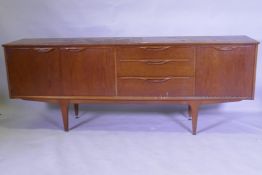 A mid century teak sideboard with two cupboards flanking three drawers, top AF, 45 x 196 x 75cm