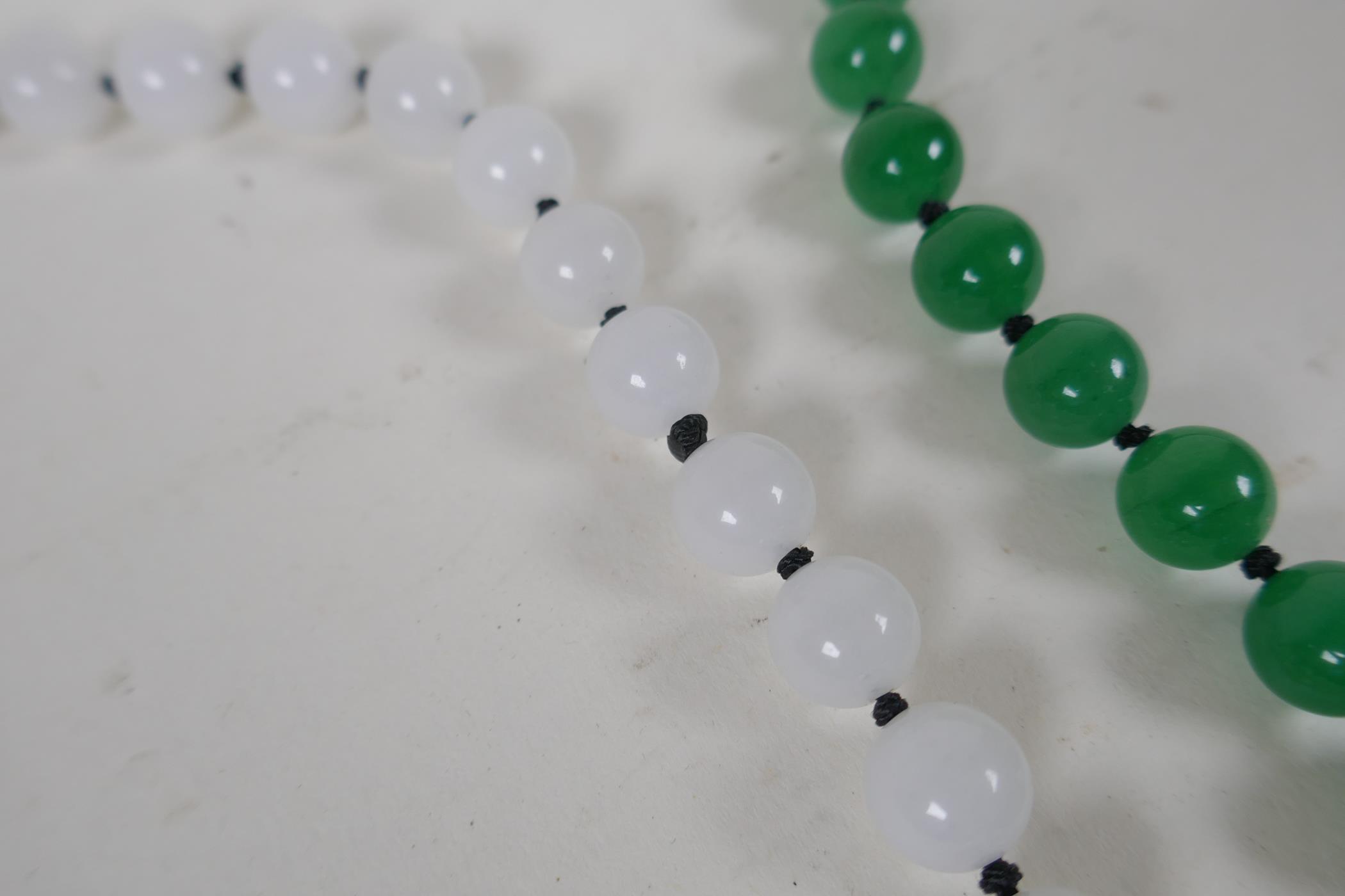 An apple green jade beaded necklace, together with a similar white jade beaded necklace, 70cm long - Image 3 of 4