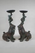 A pair of oriental bronze pricket candlesticks in the form of kylin, 46cm high
