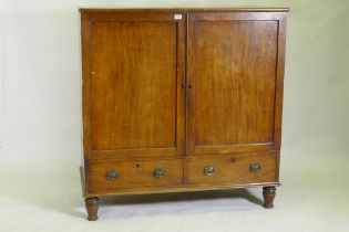 A Regency mahogany press cupboard, with two doors opening to reveal slide drawers over a single