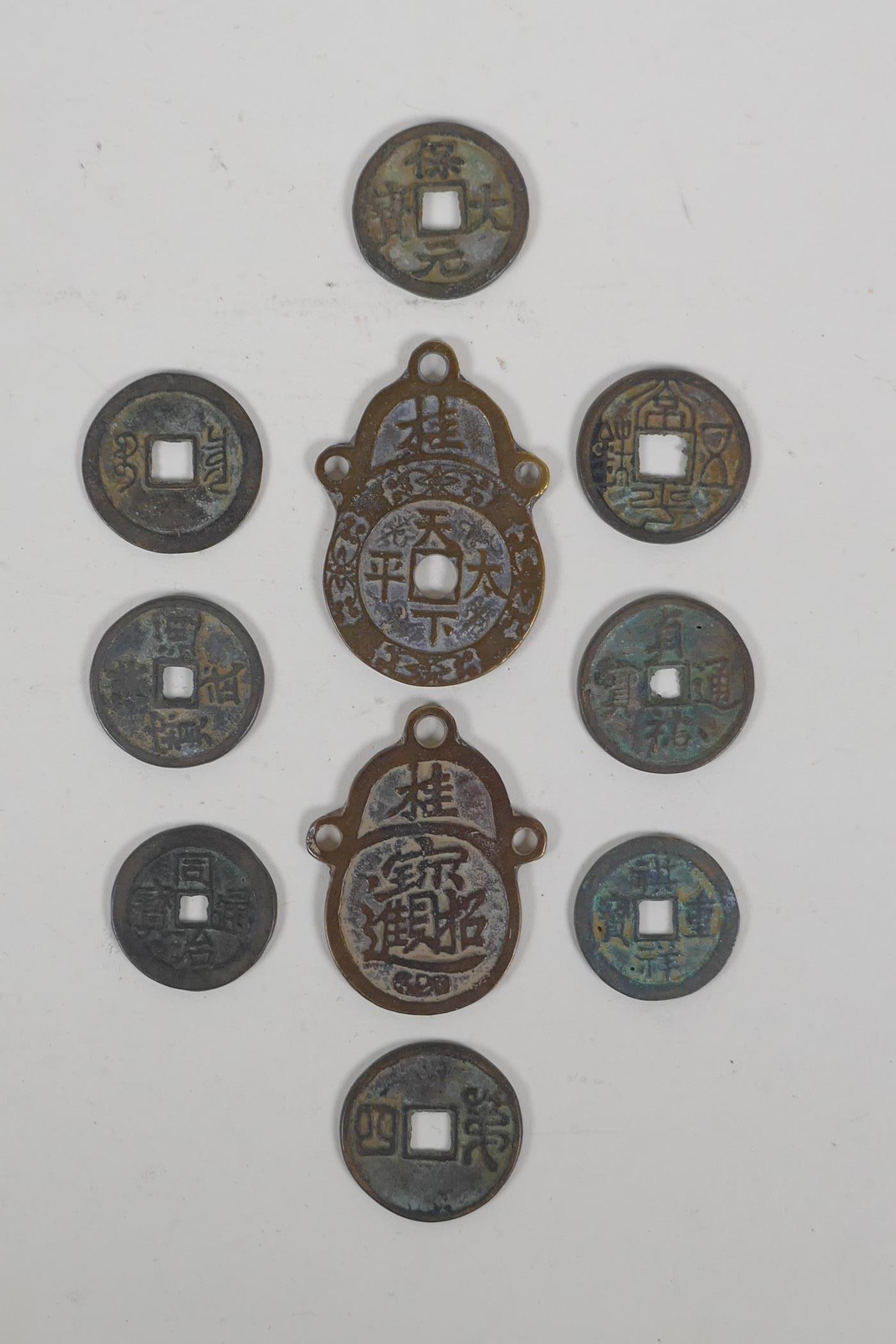 Eight Chinese facsimile (replica) bronze coins, and a pair of Chinese bronze medallions, 4 x 6cm