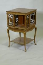 Edwardian walnut revolving bookcase with pierced fret decoration, raised on cabriole supports,