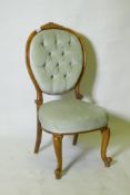 A Victorian walnut nursing chair with carved back, raised on cabriole supports