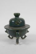 A Chinese moss green glazed porcelain censer and cover, raised on tripod scrolling feet, 13cm high