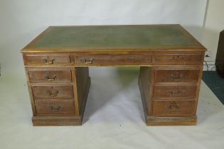 A mid C20th mahogany veneered eight drawer pedestal desk with brass swan neck handles and leather