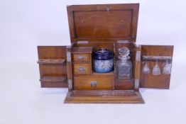 A Victorian golden oak smoker's companion, with two doors opening to reveal a fitted interior with
