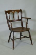 A C19th elm Oxford elbow chair with arched spindle back