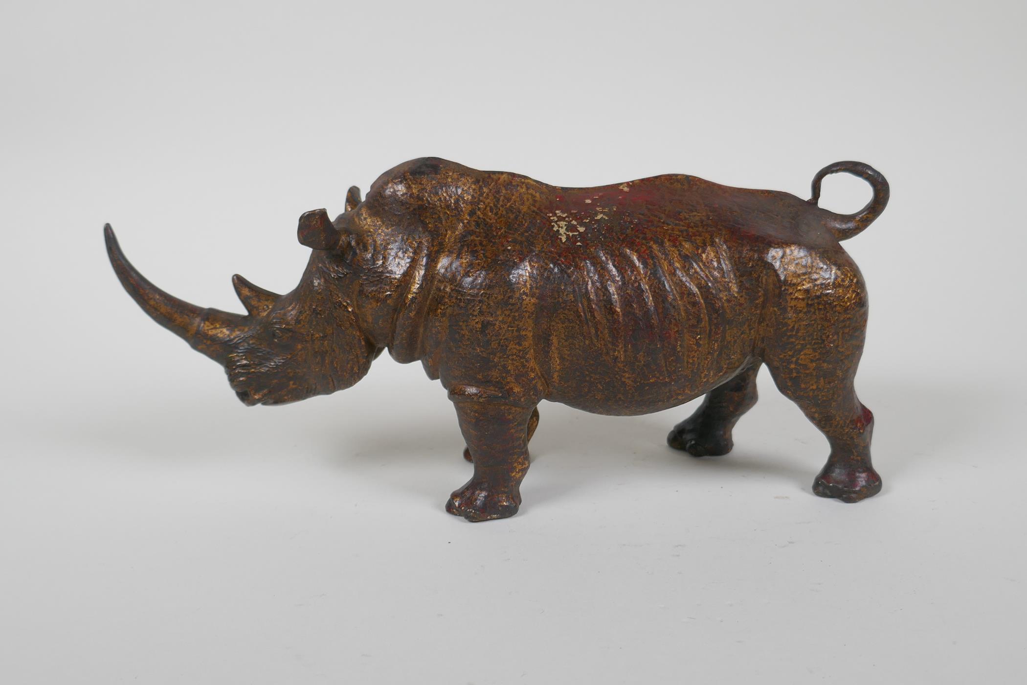 A gilt bronzed metal rhinoceros, filled, 25cm long