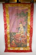 A Sino Tibetan printed tangka with gold and red silk surround, 60 x 110cm
