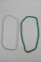 An apple green jade beaded necklace, together with a similar white jade beaded necklace, 70cm long