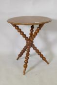 A C19th burr yew wood gypsy table, raised on crossed bobbin turned supports, 54cm diameter, 62cm