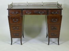 A Victorian Edwards and Roberts mahogany nine drawer pedestal desk with three quarter pierced