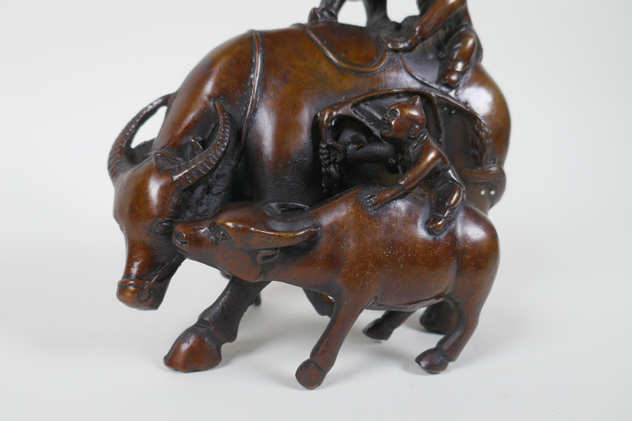 A Chinese filled bronze figure group of children playing on a buffalo, 18cm high - Image 2 of 4