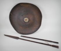 A C19th Ethiopian tribal hide shield and two ceremonial hardwood spears, one AF, shield 57cm