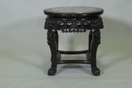 A Chinese hardwood jardiniere stand with shaped top inset with pink marble, with carved and