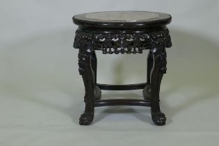 A Chinese hardwood jardiniere stand with shaped top inset with pink marble, with carved and