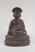 A Chinese bronze figure of a priest seated in meditation, with the remnants of gilt patina, 24cm