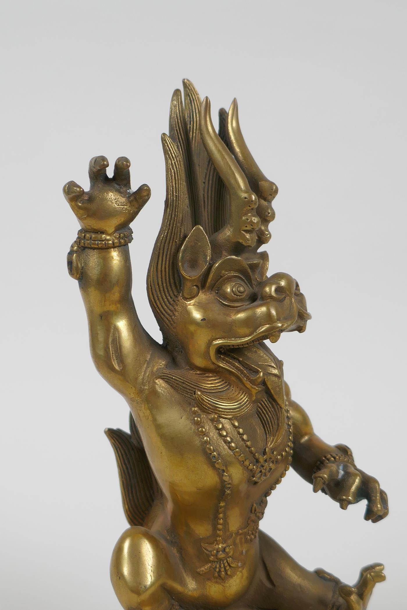 A Tibetan bronze of a wrathful beast seated on a pig, double vajra mark to base, 22cm high - Image 2 of 5