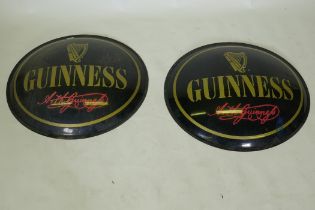 Two perspex Guinness advertising signs, 67cm diameter