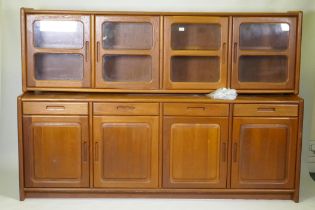 A mid century/1970s teak Danish style sideboard with four drawers over four cupboards and glazed