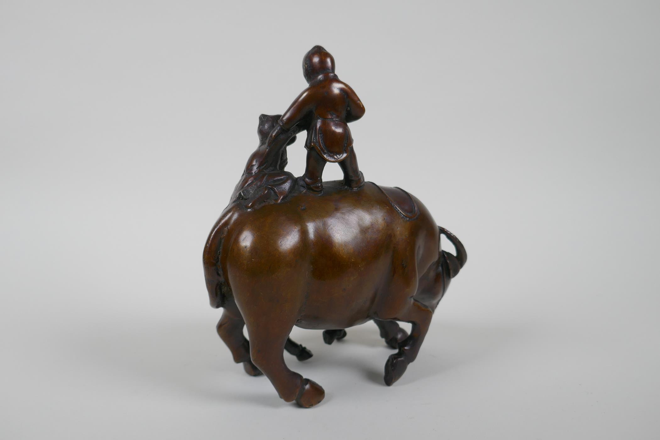 A Chinese filled bronze figure group of children playing on a buffalo, 18cm high - Image 4 of 4