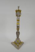 A Tibetan white metal phurba and stand, with gilt highlights, the hilt decorated with wrathful masks