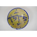 An antique Islamic pottery bowl decorated with birds and script, chips to glaze, 24cm diameter