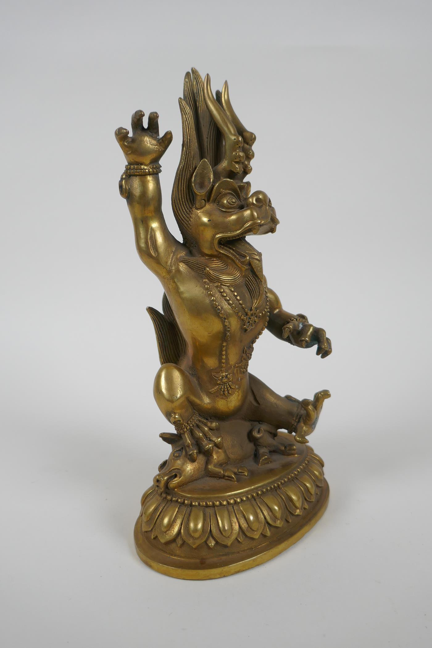 A Tibetan bronze of a wrathful beast seated on a pig, double vajra mark to base, 22cm high - Image 3 of 5