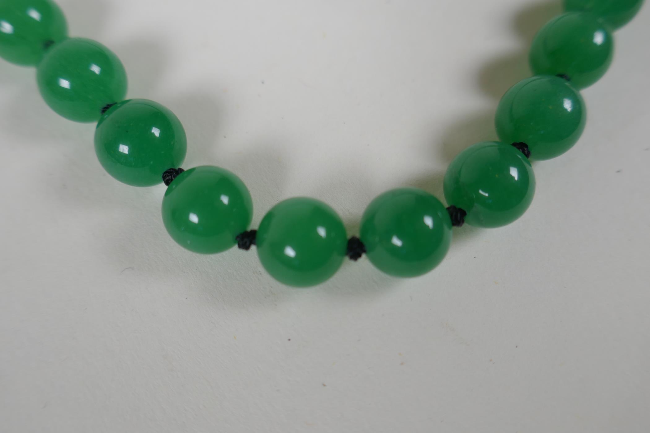 An apple green jade beaded necklace, together with a similar white jade beaded necklace, 70cm long - Image 4 of 4