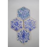 Four Iznik hexagonal pottery tiles decorated with blue and white foliate designs, 14 x 17cm