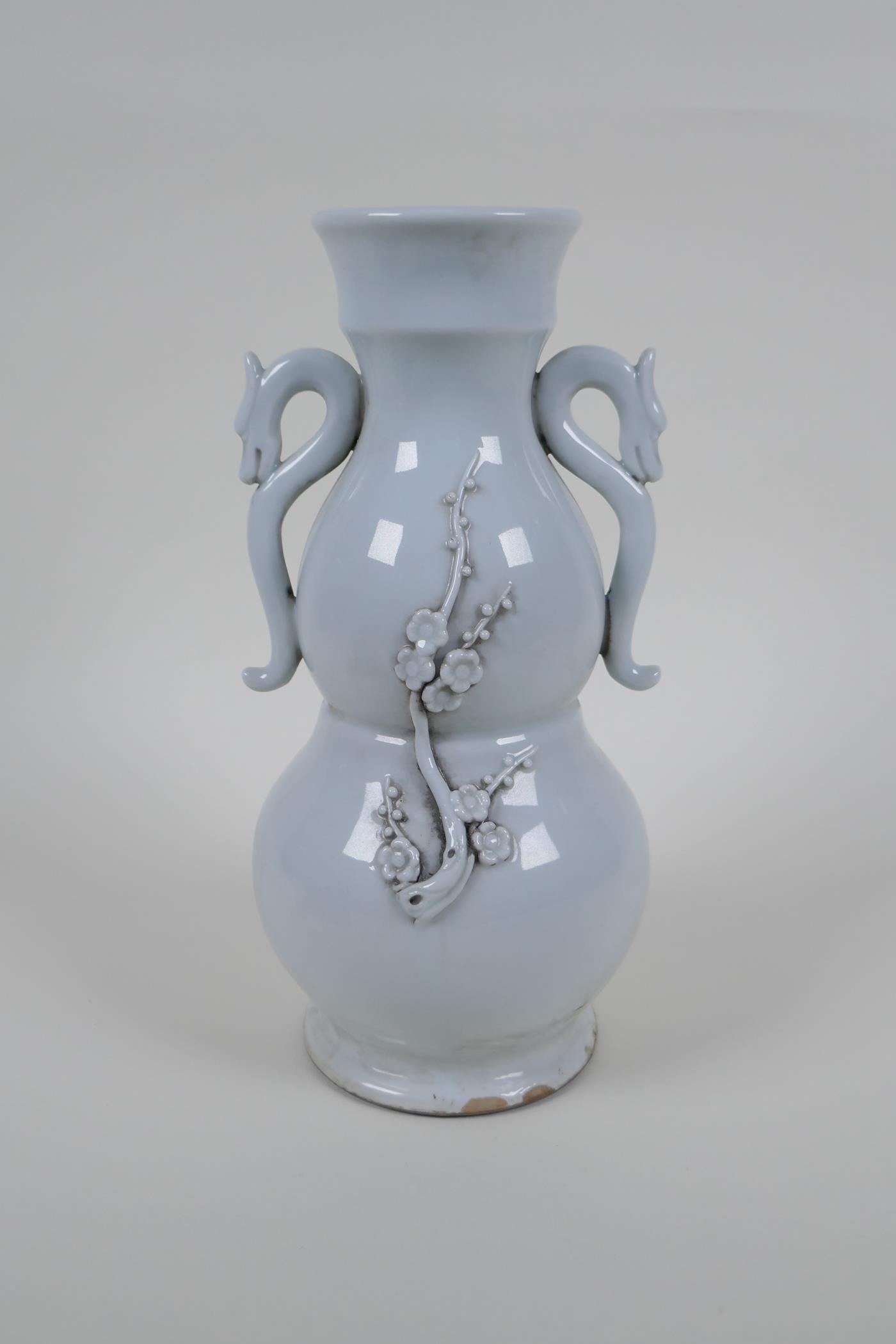 A blanc de chine porcelain two handled double gourd vase with raised prunus blossom decoration,