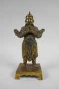 A Chinese gilt bronze figure of an immortal in armour, 4 character mark verso, 23cm high