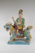 A Chinese Sancai glazed pottery figure of an immortal riding a kylin, 47cm high