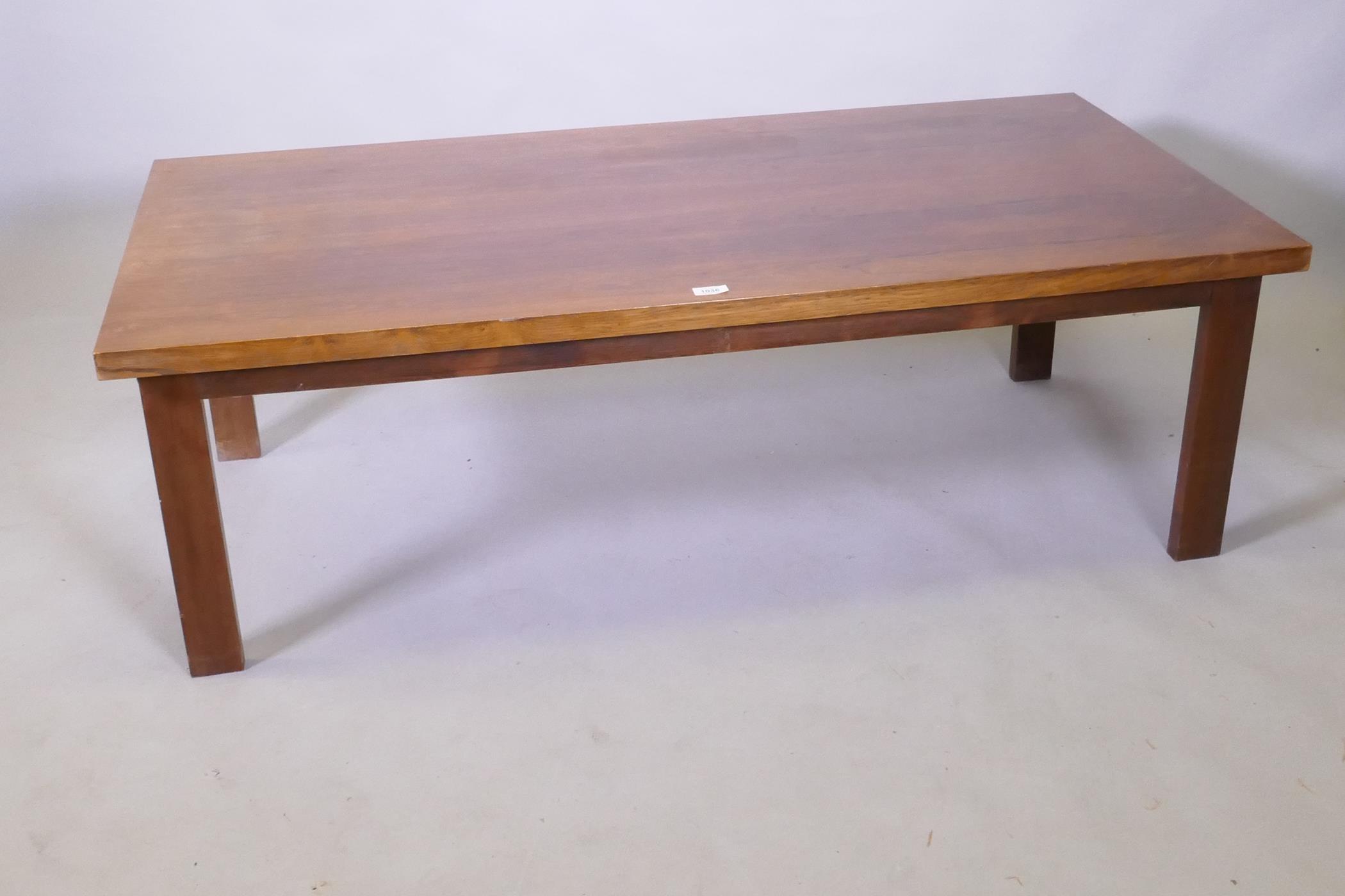 A mid century rosewood coffee table raised on square supports, 70 x 138 x 45cm