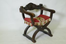 A C19th oak Glastonbury type throne chair carved with an heraldic coat of arms