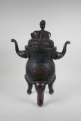 A Chinese bronzed metal two handled censer and pierced cover, raised on elephant head tripod